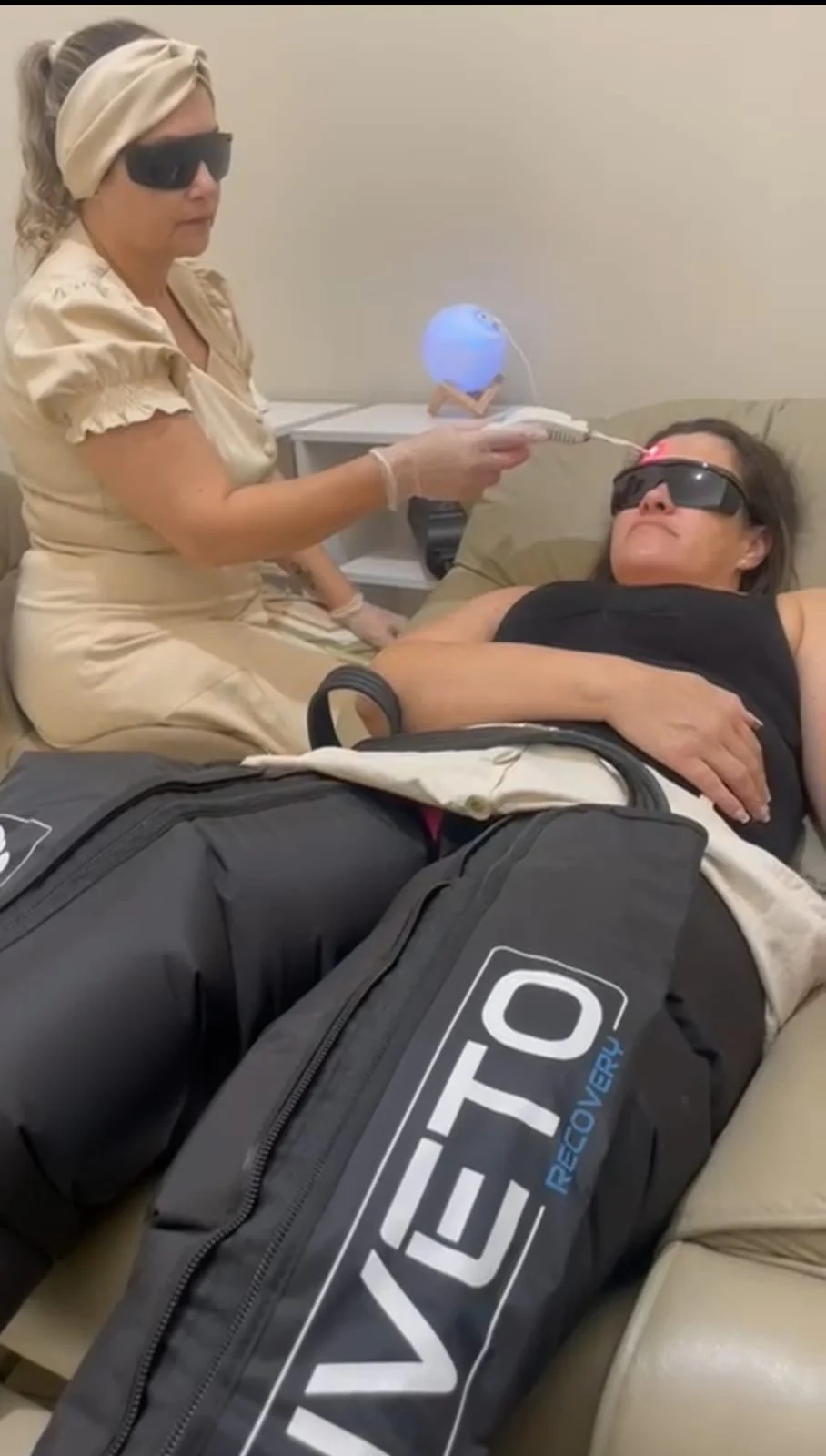 Dra. Simone realizando atendimento com fotobiomodulação e compressão pneumática em uma paciente